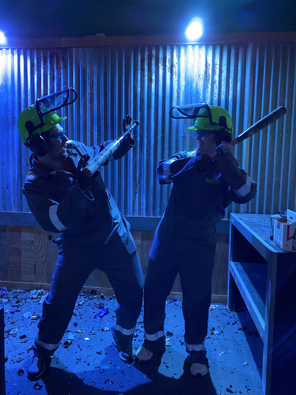 Two people with bats in smashing room at Break It Smash Rooms
